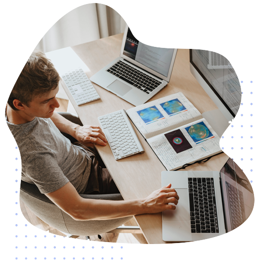 Photo of a man using multiple laptops and technology